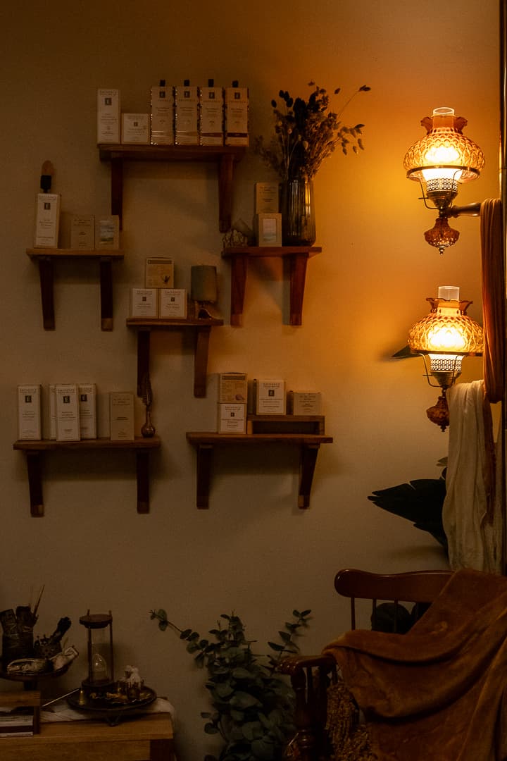 The studio — apothecary wall with Eminence shelves and amber sconces